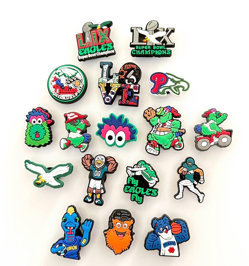 Puede incluir: Una colecci&oacute;n de coloridos dijes para zapatos con logotipos y mascotas de equipos deportivos de Filadelfia. Los dise&ntilde;os incluyen los Eagles, Phillies y Union, con textos como "Super Bowl Champions" y "Fly Eagles Fly."