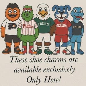 May include: Five cartoon mascots wearing jerseys with team logos. The mascots are standing in a row, from left to right: the Philadelphia Flyers, the Philadelphia Phillies, the Philadelphia Eagles, the Philadelphia Sixers, and the Philadelphia Union. The text below the mascots reads: "These shoe charms are available exclusively Only Here!"