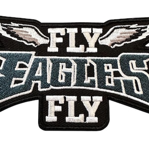 May include: Black embroidered patch with the words "FLY EAGLES FLY" in white and blue lettering. The patch has a black border and features white wings on top. A fan accessory.
