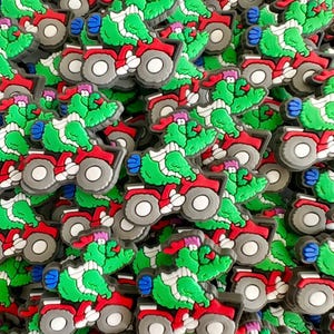 May include: A collection of colorful shoe charms featuring a green alligator riding a red ATV. The alligator has a pink hat and blue accents. The charms have gray wheels and are scattered across the image.