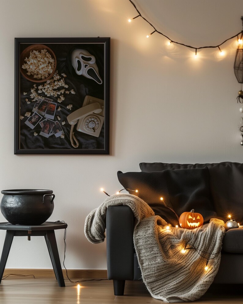 May include: A Halloween-themed living room. A framed picture features a Scream mask, popcorn, and a vintage telephone. A carved pumpkin sits on a blanket over a black sofa, lit by fairy lights. A black cauldron sits on a small table.
