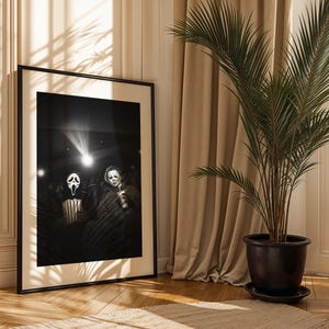 May include: Black and white framed print featuring two horror movie characters in a movie theater setting. One character wears a Scream mask and holds popcorn, the other holds a drink. A spotlight shines on them.