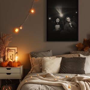 May include: A Halloween-themed bedroom scene with a framed black and white movie poster featuring characters in a theater. The room is decorated with string lights, pumpkins, and a carved jack-o'-lantern. The bed is made with gray bedding and decorative pillows.