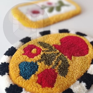 May include: A yellow oval rug with a black and white checkered border. The rug has a floral design with red, green, and blue flowers.