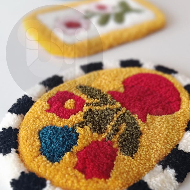 May include: A yellow oval rug with a black and white checkered border. The rug has a floral design with red, green, and blue flowers.