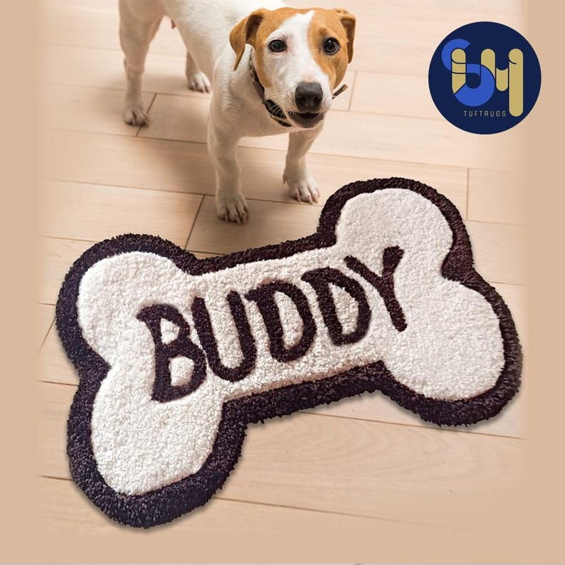 May include: White bone-shaped doormat with a brown border and the word "BUDDY" in brown lettering.