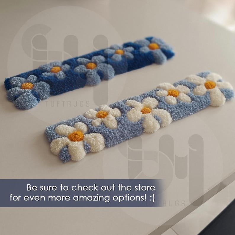 May include: Two rectangular, tufted rugs with daisy patterns. One is light blue with white and yellow daisies, the other is dark blue with white and yellow daisies. The text "TUFTRUGS" is visible. The text "Be sure to check out the store for even more amazing options! :)" is also visible.