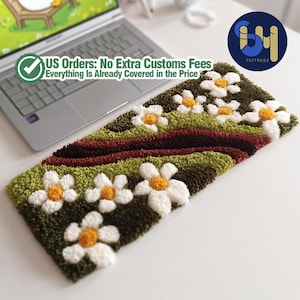 May include: A rectangular, tufted rug featuring a daisy floral design. The rug has a dark green background with white daisies and yellow centers. The text "US Orders: No Extra Customs Fees Everything Is Already Covered in the Price" is visible.