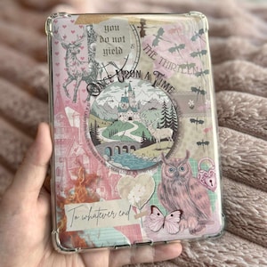 May include: Clear phone case with a pink and beige collage design. The design includes a castle, deer, owl, butterflies, and the phrases "Once Upon a Time", "To whatever end", and "You do not yield".