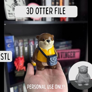 Peut inclure: Figurine d'une loutre marron et beige portant une chemise jaune et un sac bleu. L'image comprend le texte "3D OTTER FILE", "STL" et "PERSONAL USE ONLY!". Un modèle 3D de la loutre est dans le coin inférieur droit.