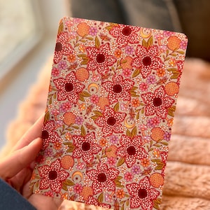 May include: A rectangular floral patterned card featuring a repeating design of large red flowers with white speckles, surrounded by smaller flowers, mushrooms, and crescent moons. The background is a light gray color, and the overall design has a vintage aesthetic.