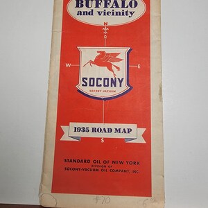 May include: Vintage 1935 road map for Buffalo and vicinity. The cover is red with white and blue text and graphics, including the Socony logo. The map is from the Standard Oil of New York.