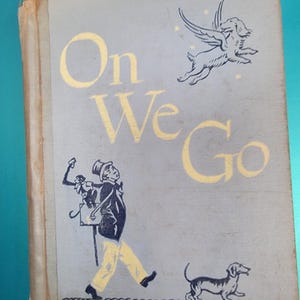 May include: Vintage children's book titled "On We Go" with illustrations. The cover features a drawing of a man, a dog, and a winged dog. The title is in large gold letters. The words "Reading for Meaning" are at the bottom.