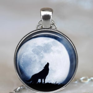 May include: A silver necklace with a round pendant featuring a black wolf silhouette howling at a full moon.