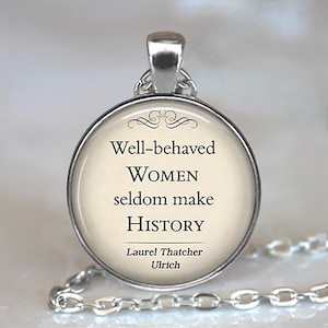 May include: A silver-toned pendant necklace with a round, cream-colored charm. The charm features the quote "Well-behaved WOMEN seldom make HISTORY" attributed to Laurel Thatcher Ulrich. The pendant has a decorative silver bail and a linked chain.