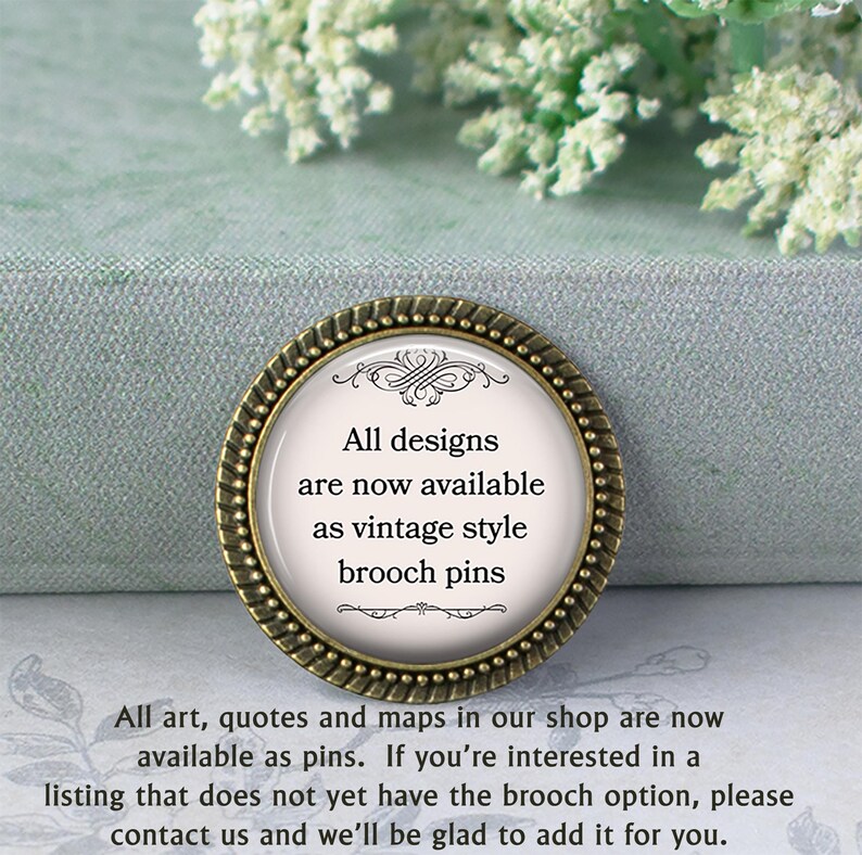a decorative pin with text, placed on a surface with a floral pattern. The pin announces that all designs are now available as vintage style brooch pins, and that all art, quotes, and maps in the shop are now available as pins. If someone is interested in a listing that does not yet have the brooch option, they should contact the shop and the staff will be happy to add it for them.