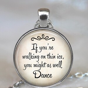 May include: Silver necklace with a round glass pendant featuring a vintage-style background with the text "If you're walking on thin ice, you might as well Dance."