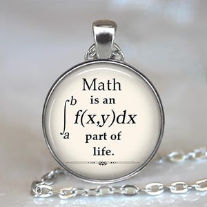 May include: A silver-toned pendant necklace with a round charm. The charm features the text "Math is an integral part of life" in black font. The necklace has a delicate chain.