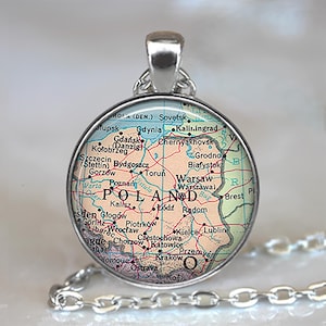 May include: A silver-toned pendant necklace featuring a circular charm with a map of Poland. The map displays cities like Warsaw, Krakow, and Gdansk, with a silver chain attached.