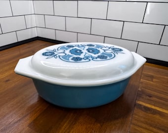 Vintage Pyrex 2.5 pint covered casserole dish featuring a classic blue floral pattern on a white milk glass base.
