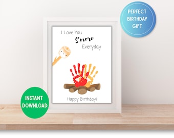 May include: A framed print with the text "I Love You S'more Everyday" and "Happy Birthday!" features a campfire made of handprints and logs, with a marshmallow character. Includes "Instant Download" and "Perfect Birthday Gift" labels.