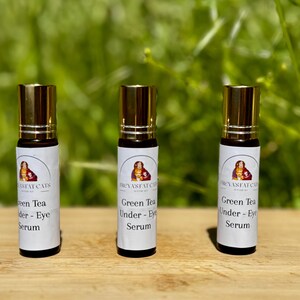 Peut inclure: Trois flacons en verre avec des bouchons dor&eacute;s et des &eacute;tiquettes blanches. Les &eacute;tiquettes portent le texte "REVASFAT CATS" et "Green Tea Under - Eye Serum".