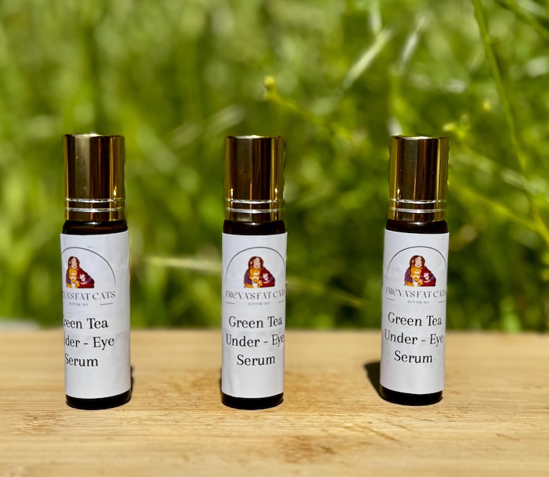 Peut inclure: Trois flacons en verre avec des bouchons dor&eacute;s et des &eacute;tiquettes blanches. Les &eacute;tiquettes portent le texte "REVASFAT CATS" et "Green Tea Under - Eye Serum".