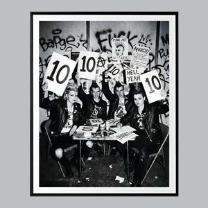 Może przedstawiać: Czarno-białe zdjęcie grupy punków trzymających tablice z numerem 10. Tło zawiera graffiti i napisy, takie jak "Punk Art" i "Anarchy", odzwierciedlające estetykę punk.