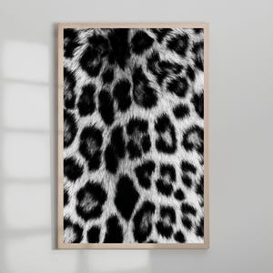 Pu&ograve; includere: Stampa incorniciata con un motivo leopardato in bianco e nero. Il design presenta un motivo ripetuto di macchie nere su sfondo bianco, creando un effetto strutturato ad alto contrasto. La stampa &egrave; racchiusa in una cornice di legno chiaro.