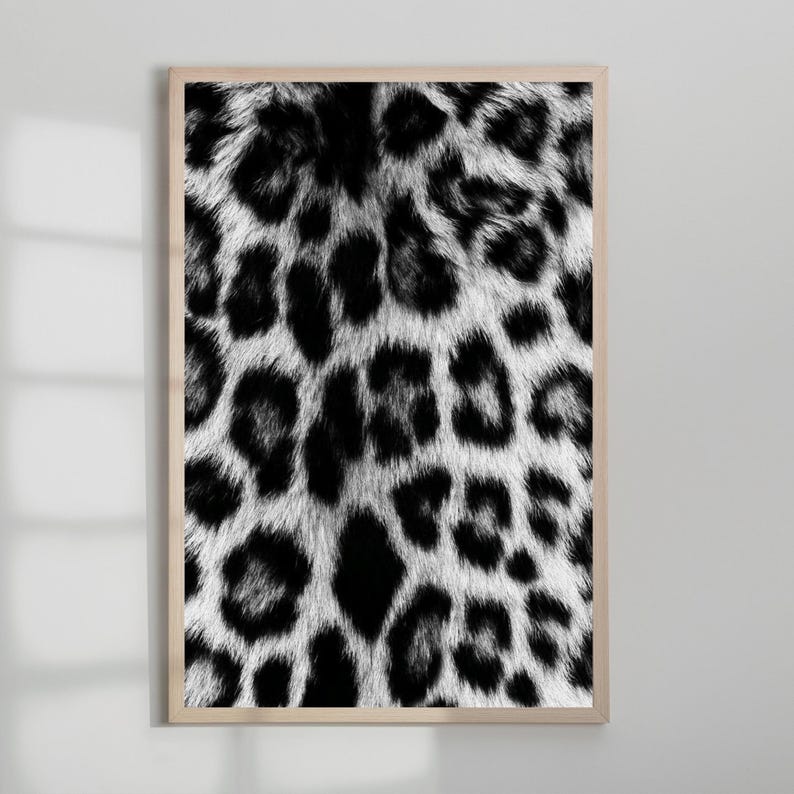 Pu&ograve; includere: Stampa incorniciata con un motivo leopardato in bianco e nero. Il design presenta un motivo ripetuto di macchie nere su sfondo bianco, creando un effetto strutturato ad alto contrasto. La stampa &egrave; racchiusa in una cornice di legno chiaro.