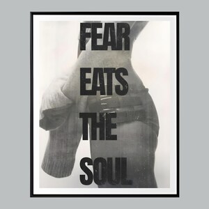May include: Monochrome framed art print featuring the phrase "FEAR EATS THE SOUL" in bold, uppercase letters. The image is a grayscale photograph of a person's torso and arm, with a blurred, textured effect.