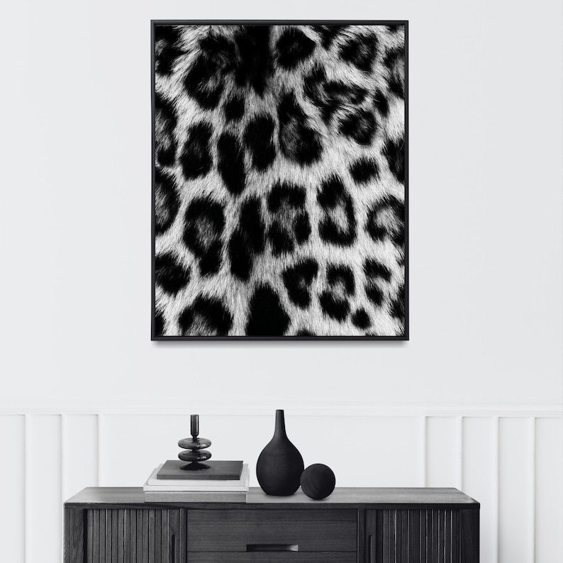 Pu&ograve; includere: Stampa artistica incorniciata in bianco e nero con un motivo leopardato. L'immagine in bianco e nero &egrave; incorniciata in nero. L'opera d'arte &egrave; esposta su una parete bianca sopra un mobile in legno scuro.