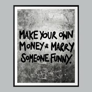 Könnte beinhalten: Gerahmter Kunstdruck mit dem Text "MAKE YOUR OWN MONEY & MARRY SOMEONE FUNNY" in schwarzer Handschrift. Der Hintergrund hat eine strukturierte, silberne Metallic-Optik.