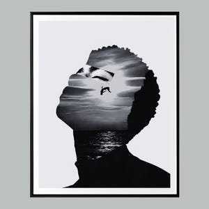Peut inclure: Impression artistique en noir et blanc représentant le profil d'une personne regardant vers le haut, avec un paysage marin et un ciel intégré dans la tête. L'image est encadrée en noir, créant un fort contraste.