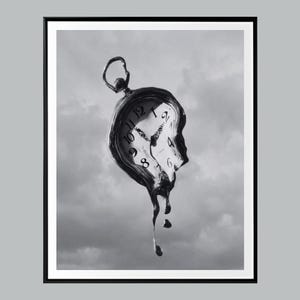 Puede incluir: Impresión en blanco y negro de un reloj de bolsillo derritiéndose contra un cielo nublado. La esfera del reloj muestra números romanos. El reloj parece estar goteando, creando un efecto surrealista. La obra de arte está enmarcada en un borde negro.