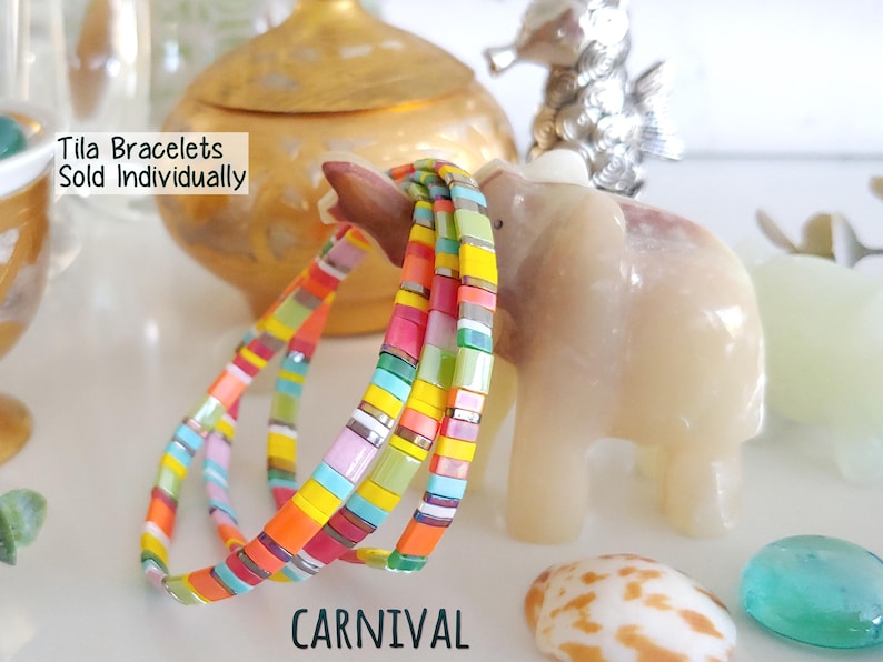 Peut inclure: Un ensemble de bracelets Tila compos&eacute; de perles carr&eacute;es multicolores dans des tons orange, jaune, rose, bleu et vert. Le texte "Tila Bracelets Sold Individually" et "CARNIVAL" est imprim&eacute; sur l'image.