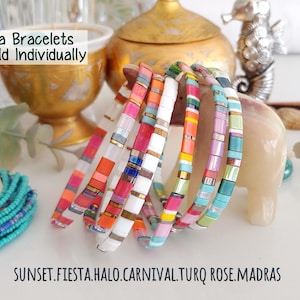 Peut inclure: Une collection de bracelets Tila compos&eacute;s de perles carr&eacute;es et plates aux motifs multicolores vibrants, notamment rose, orange, blanc, jaune et turquoise. Le texte Tila Bracelets Sold Individually et les noms SUNSET, FIESTA, HALO, CARNIVAL, TURQ ROSE, MADRAS sont visibles.