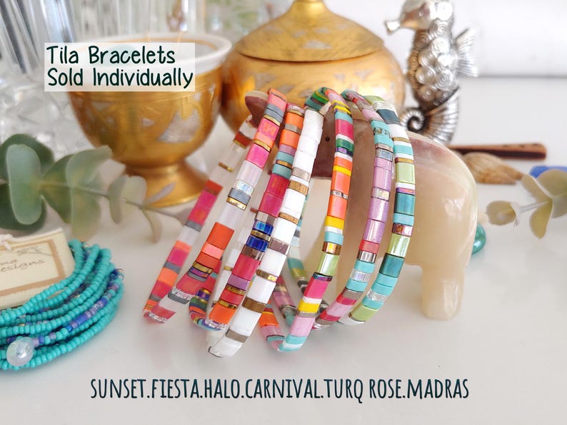 Peut inclure: Une collection de bracelets Tila compos&eacute;s de perles carr&eacute;es et plates aux motifs multicolores vibrants, notamment rose, orange, blanc, jaune et turquoise. Le texte Tila Bracelets Sold Individually et les noms SUNSET, FIESTA, HALO, CARNIVAL, TURQ ROSE, MADRAS sont visibles.
