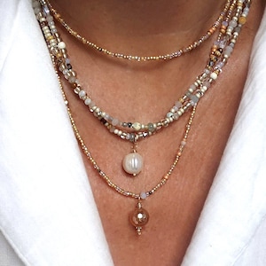 Collar largo de cuentas con piedras brillantes y cierre chapado en oro.