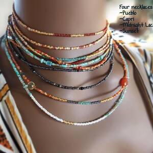 May include: Four beaded necklaces in different colours, layered together. The necklaces are labelled Pueblo, Capri, Midnight Lacquer, and Sunset. The image includes the text: "Four necklaces stacked: ~Pueblo ~Capri ~Midnight Lacquer ~Sunset."