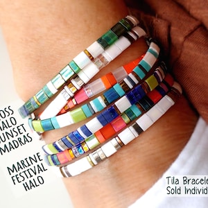 Peut inclure: Un empilement de cinq bracelets de perles Tila multicolores avec des motifs vari&eacute;s de perles blanches, vertes, bleues, orange et m&eacute;talliques. Une carte blanche affiche le texte MOSS HALO SUNSET MADRAS MARINE FESTIVAL HALO et Tila Bracelets Sold Individually.