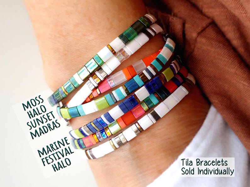 Peut inclure: Un empilement de cinq bracelets de perles Tila multicolores avec des motifs vari&eacute;s de perles blanches, vertes, bleues, orange et m&eacute;talliques. Une carte blanche affiche le texte MOSS HALO SUNSET MADRAS MARINE FESTIVAL HALO et Tila Bracelets Sold Individually.