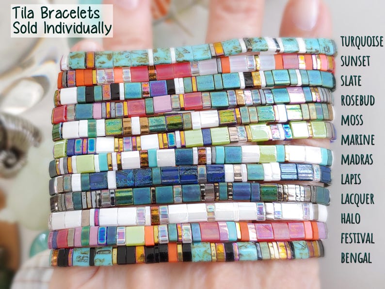 Peut inclure: Une collection de bracelets Tila vendus individuellement, compos&eacute;s de perles carr&eacute;es aux motifs vari&eacute;s incluant turquoise, sunset, slate, rosebud, moss, marine, madras, lapis, lacquer, halo, festival et bengal. Le texte indique Tila Bracelets Sold Individually.
