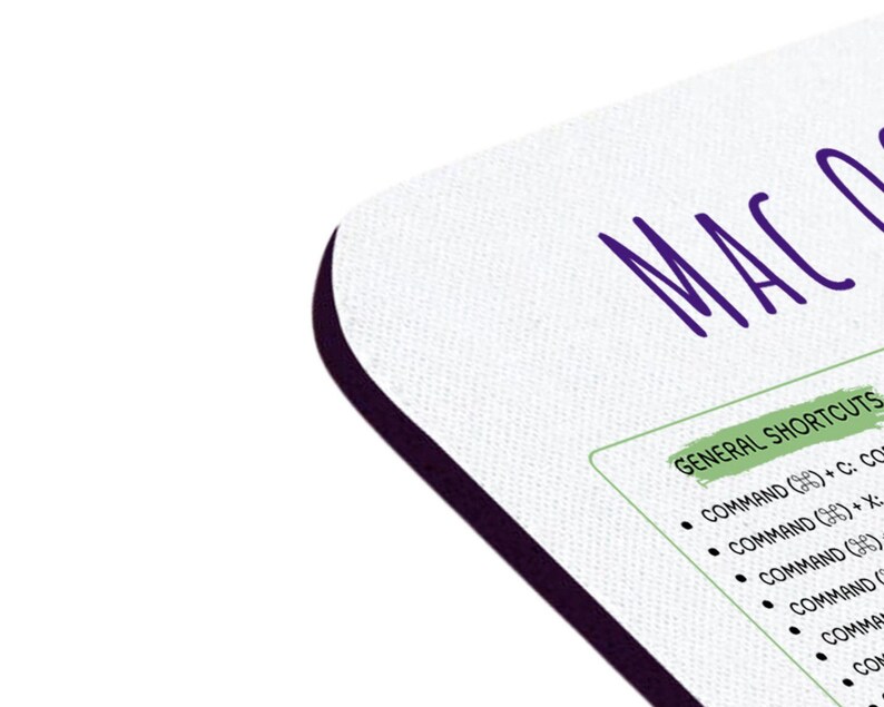May include: A white mousepad with a black border. The text "MACO" is written in purple at the top of the mousepad. Below the text, a list of "GENERAL SHORTCUTS" is written in green. The list includes keyboard shortcuts for a Mac computer.