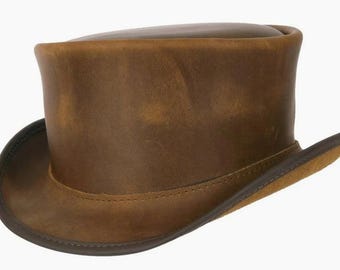 May include: A brown leather top hat with a wide brim. The hat has a distressed look, giving it a vintage feel.