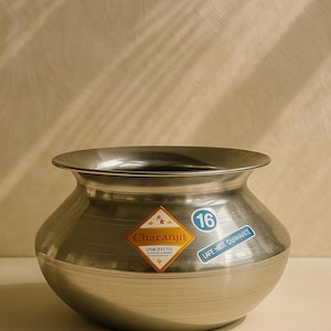 以下が含まれることがあります： 幅広で丸みを帯びたボディとフレアリムを備えたステンレス製の調理鍋。鍋の容量は16で、テキスト付きのステッカーが2枚付いています。鍋は調理と食品の準備のために設計されています。