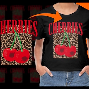 May include: Black t-shirt featuring a red text design that says "CHERRIES" above a graphic of two red cherries with green stems. The cherries are set against a leopard print background.