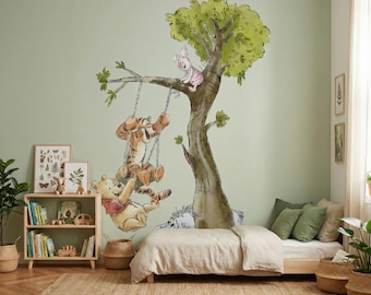 May include: A whimsical nursery scene featuring a large wall mural of Winnie the Pooh characters swinging from a tree. The room includes a wooden bed, a bookshelf with books, and a woven rug, creating a cozy and playful atmosphere.