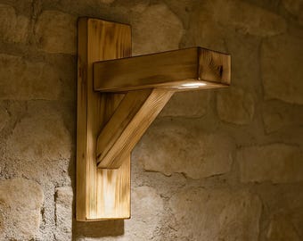 May include: A wooden wall sconce with a light fixture. The sconce is made of natural wood and has a rustic look. It is mounted on a stone wall.