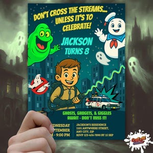Hand holding printed Ghostbusters birthday invitation featuring Slimer, Stay Puft, Ecto-1, and proton pack; cartoon kids party invite.